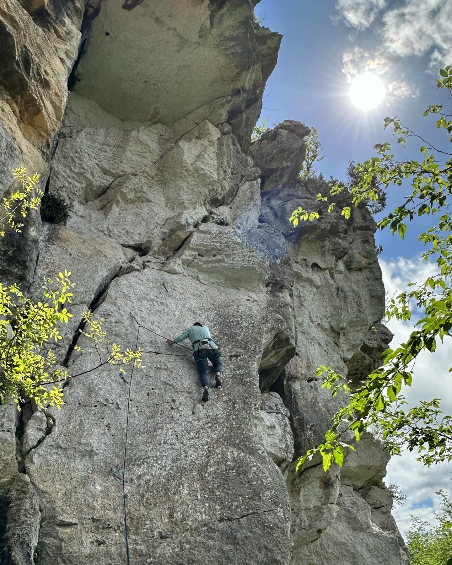 A focused climber contemplating the next move on a steep alpine cliff during a two-day workshop.