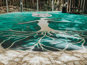 A serene view of the yoga shala at Lunita Jungle Retreat Center, Mexico, featuring a striking tree-like mural on the floor, blending harmoniously with the lush forest backdrop.