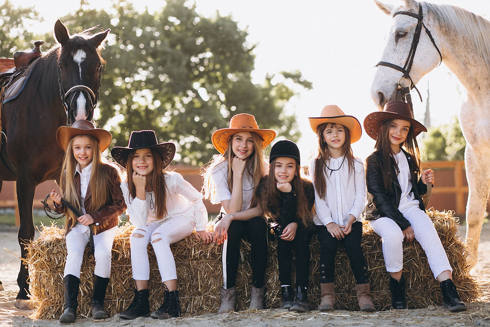 group-girls-sitting-hay-with-horses.jpg