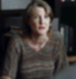 a concerned older woman in a vneck striped sweater in brown tones