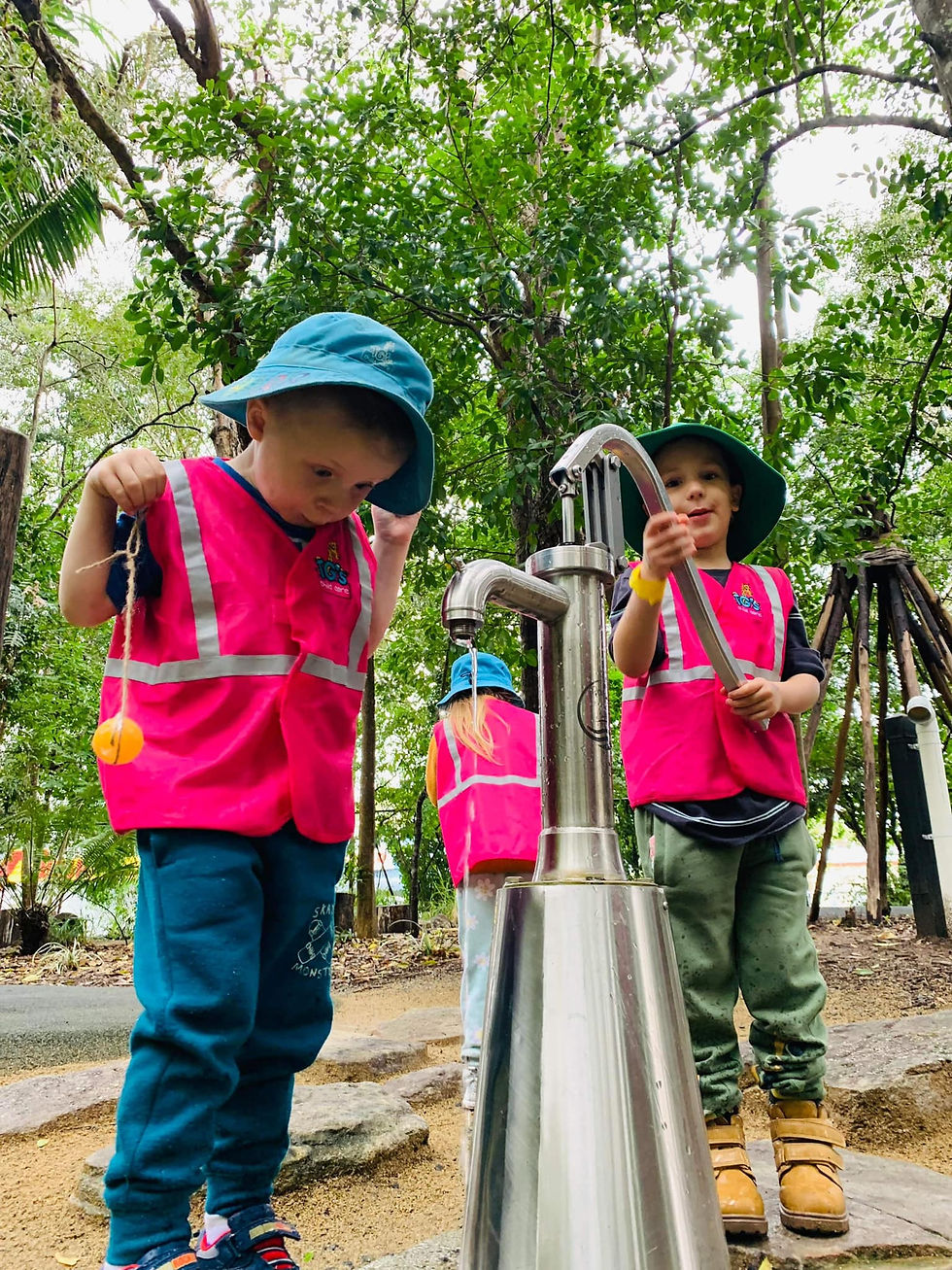 Two children operating a water pump at TG's Child Care