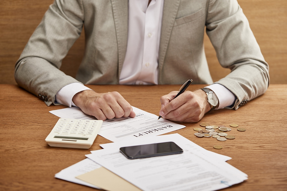 Cropped view of a businessman in suit filling in bankruptcy form at wooden table