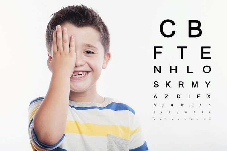 A young child reading letters off an eye chart