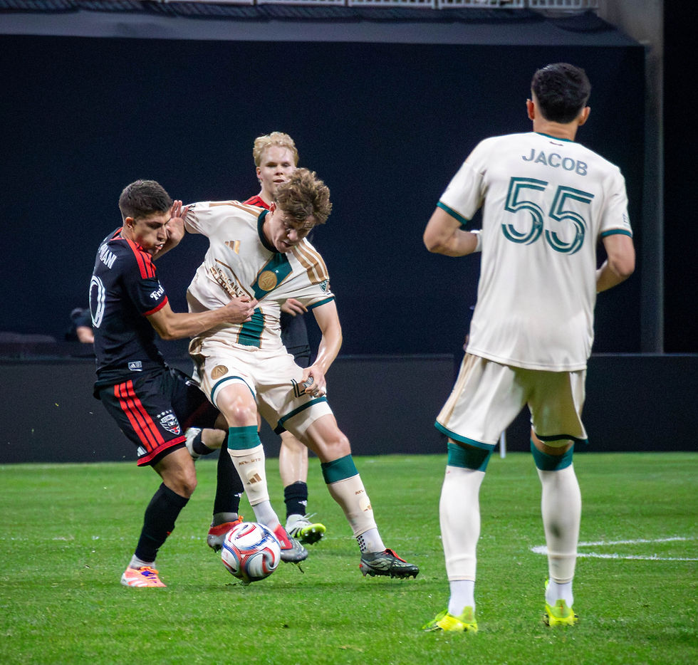 Soccer match with players in white and black jerseys battling for the ball. One player's jersey shows the name Jacob and number 55.