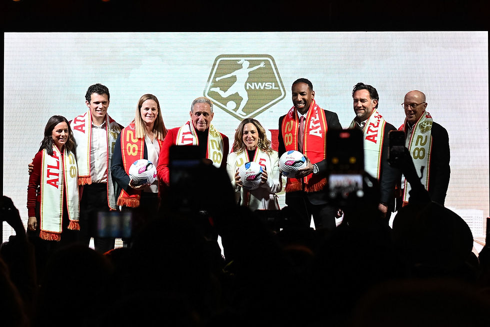 Group photo of seven people wearing red ATLANTA scarves, holding soccer balls. NWSL logo in background, with a joyful atmosphere.