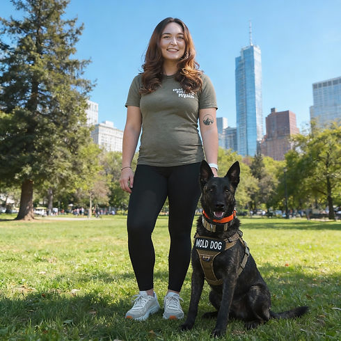 Woman and black service dog with "HOLD DOG" harness in park.