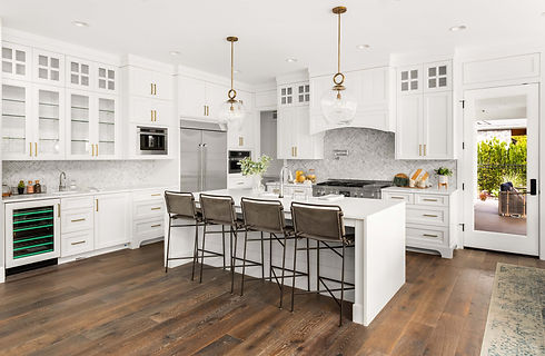 A modern kitchen featuring white cabinets and a central island, designed by Montana Cabinets Renew.
