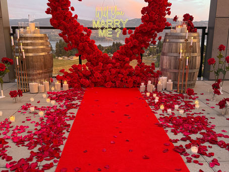 Romantic private winery proposal at sunset with floral heart backdrop in Kelowna