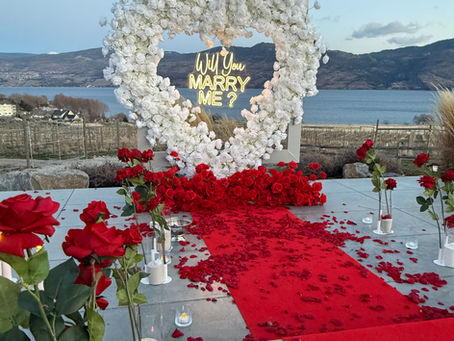 Romantic engagement proposal Kelowna with luxury white florals candles and intimate sunset setting