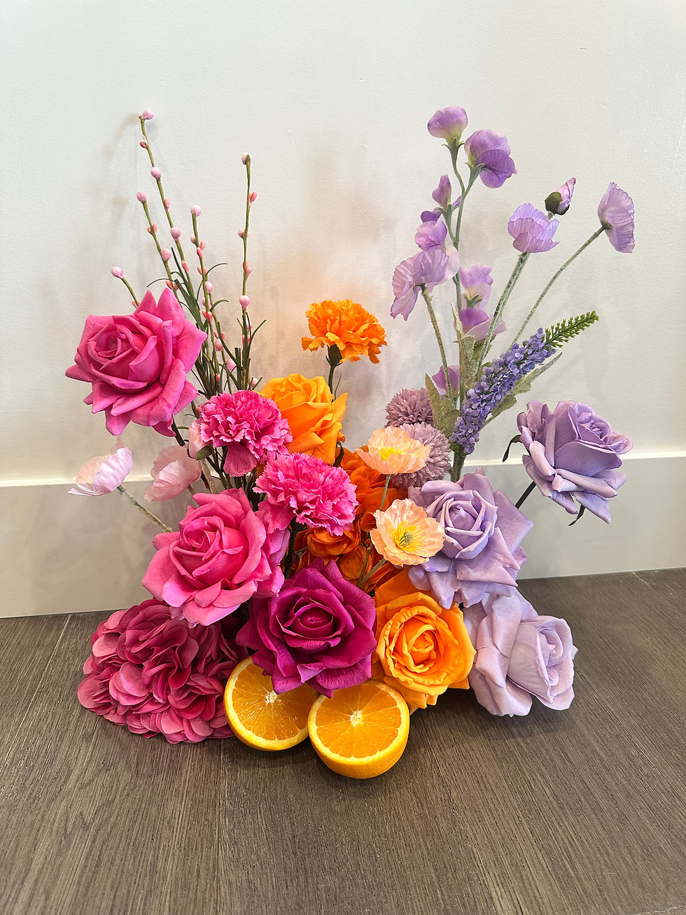 Colourful Real Touch bar arrangement with pink, orange, and lavender flowers with citrus slices faux flower rental Kelowna