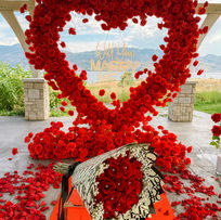 Oversized red rose heart proposal setup at Sanctuary Gardens in West Kelowna with vineyard and Okanagan Lake views.