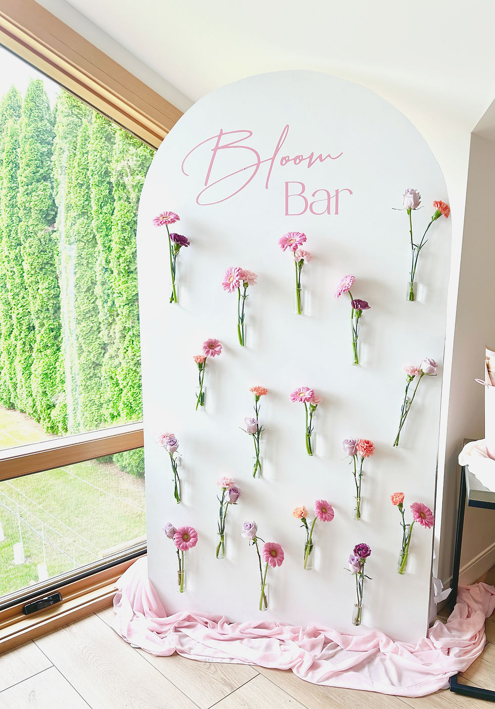 “Bloom Bar” station with mini bud vases and flowers for guests to create take-home arrangements at a Baby in Bloom-themed baby shower.