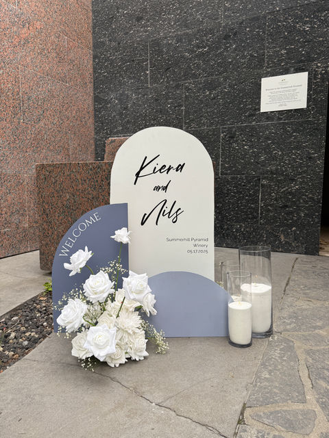 Triple arch wedding welcome sign with white faux florals, ideal for a stylish Kelowna ceremony entrance.