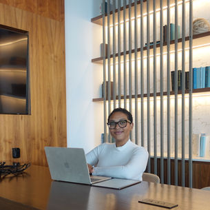 Renate Matroos is a leadership facilitator sitting at a board room table