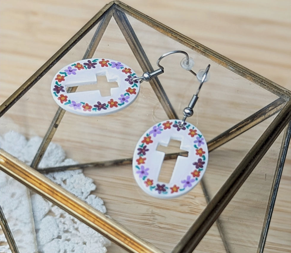 Bijou fait main fleurs mauves et oranges sur base blanche forme ovale.