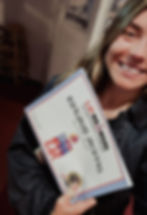 Smiling woman holding an Ironman qualifier certificate