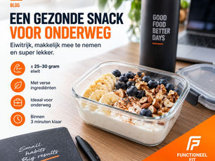 Blog met bakje yoghurt, banaan, blauwe bessen en noten op bureau; tekst: Een gezonde snack voor onderweg.