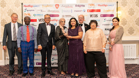 The Wesley Hall Community Centre team stands together at the VAL Awards 2025 ceremony holding their City Charity of the Year trophy, with sponsor logos displayed on the backdrop.
