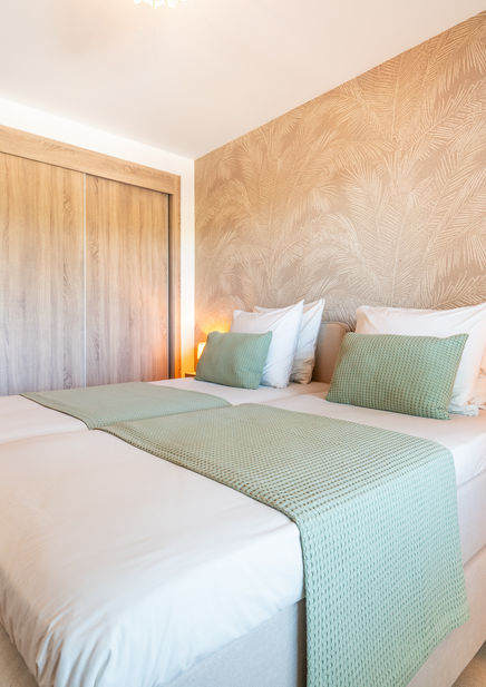 Peaceful palm design bedroom with luxury bedding in Casa Sunny Golf holiday apartment in Spain.