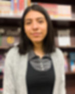 Photograph of Leslie in front of a bookshelf at the library