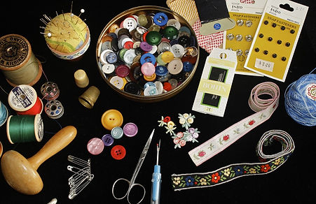 A collection of sewing items including ribbons, threads, and scissors.