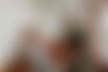 bride smiling while makeup artist puts on mascara