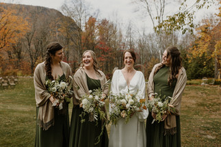 bride and bridesmaids laughing holding bouquets