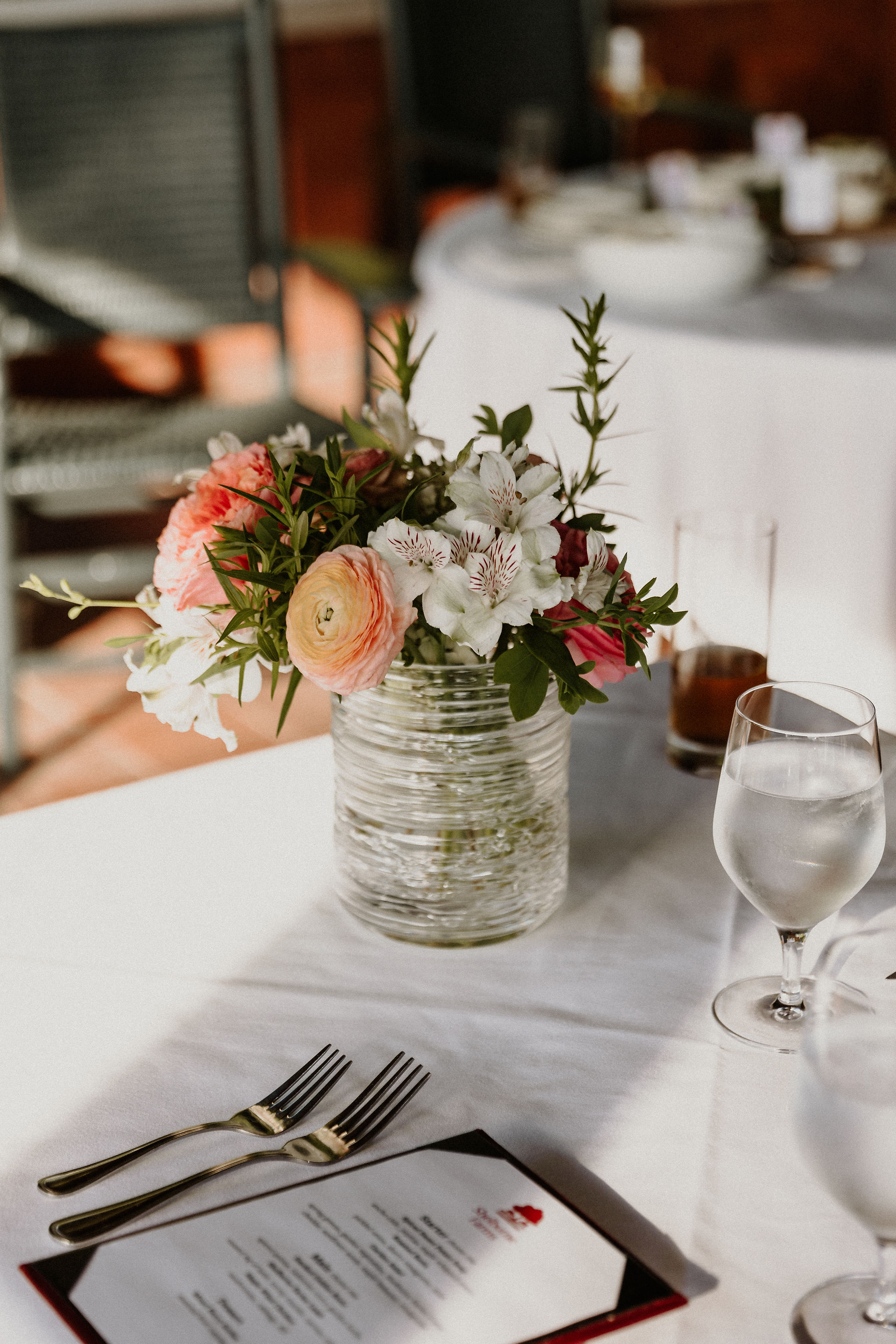 summer floral display on white tablecloth next to food menu