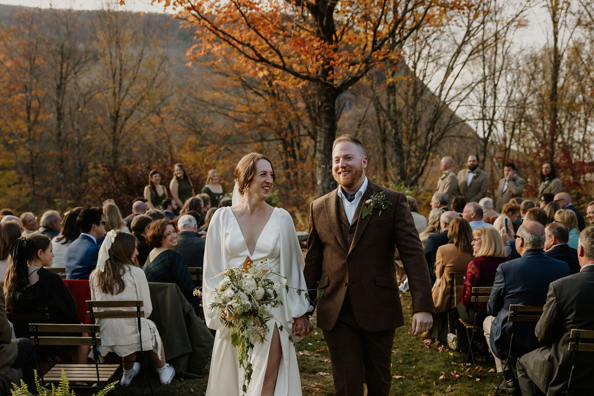 bride and groom recessing down the aisle after the ceremony holding hands and smiling