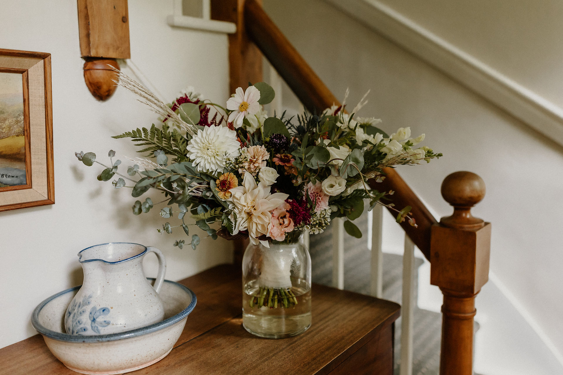 wedding floral bouquet in glass vase sitting on wooden table