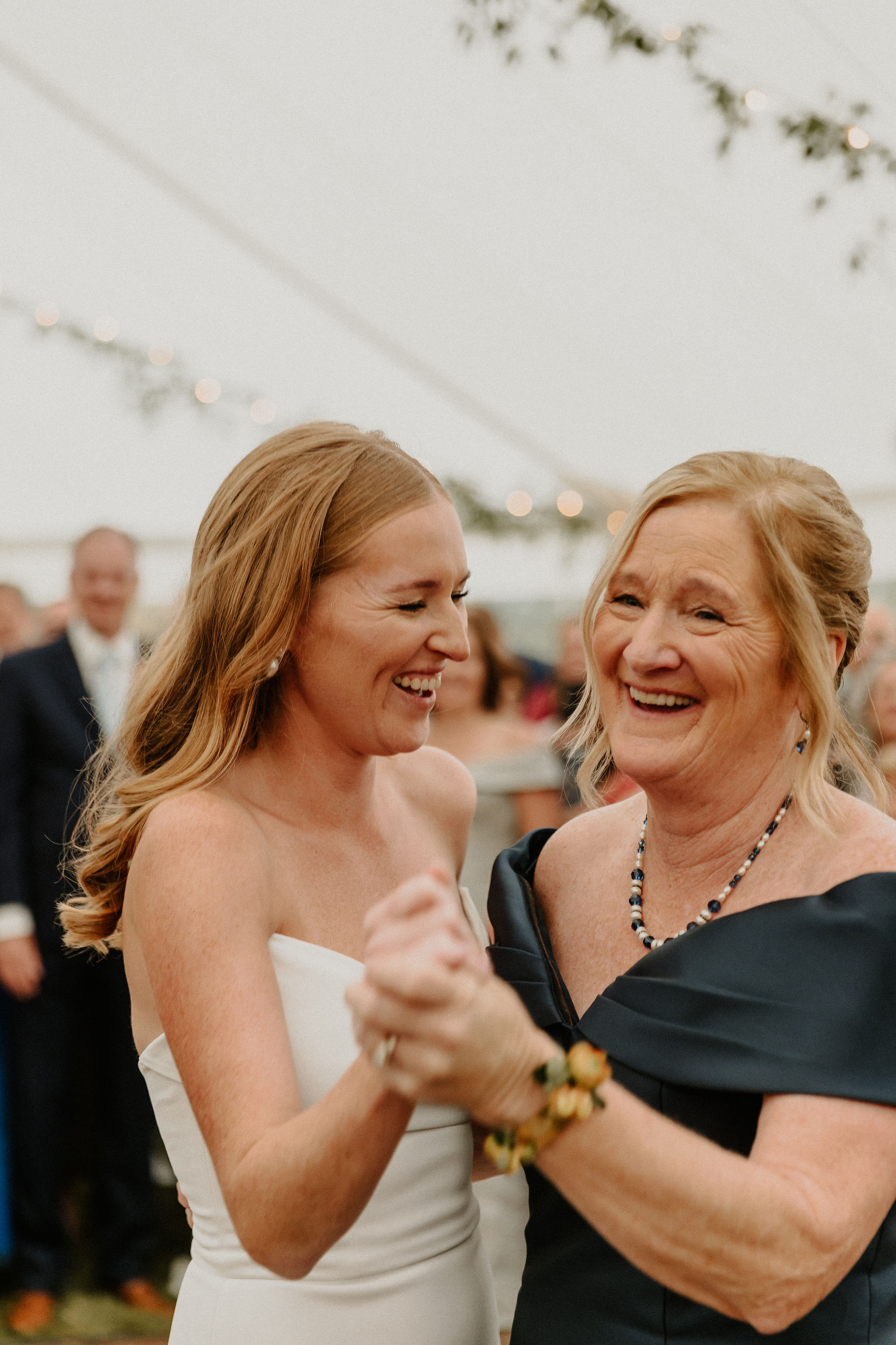 Bride and her mom laugh while sharing a special dance.