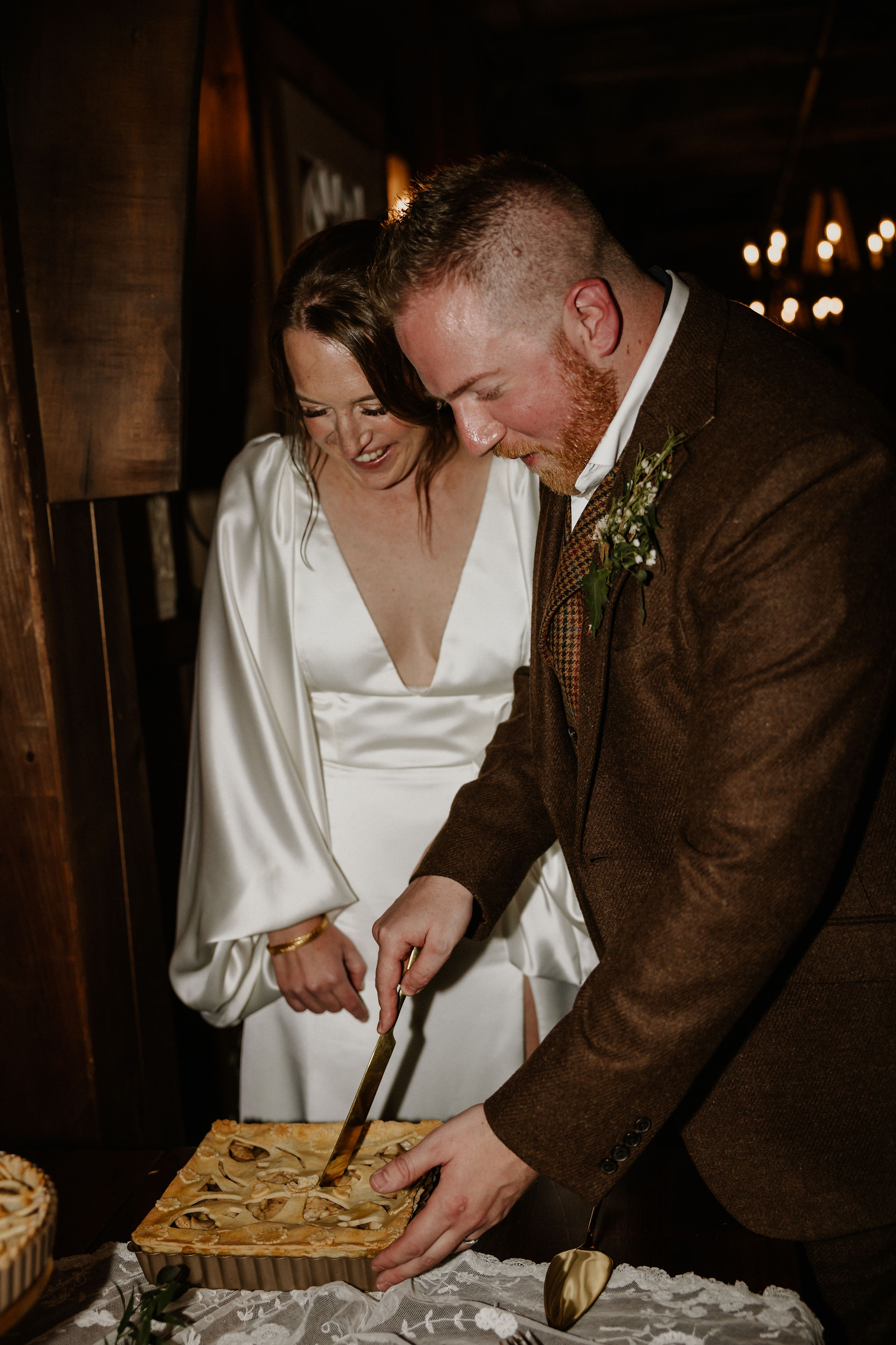 bride and groom cut their wedding pie