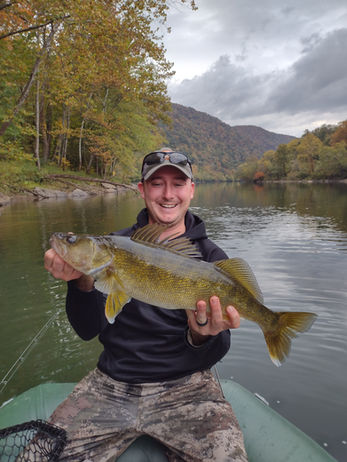 Fisherman with a smallmouth bass caught in the river.