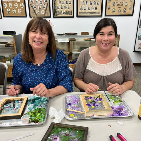 Two women smiling making art