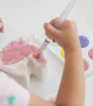 Child painting pottery