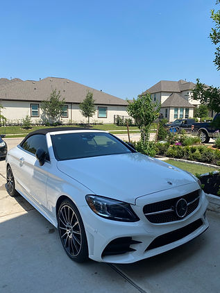 Shiny red car reflecting sunlight after a premium hand wash and wax treatment.
