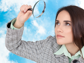 Curious girl looking through a magnifying glass