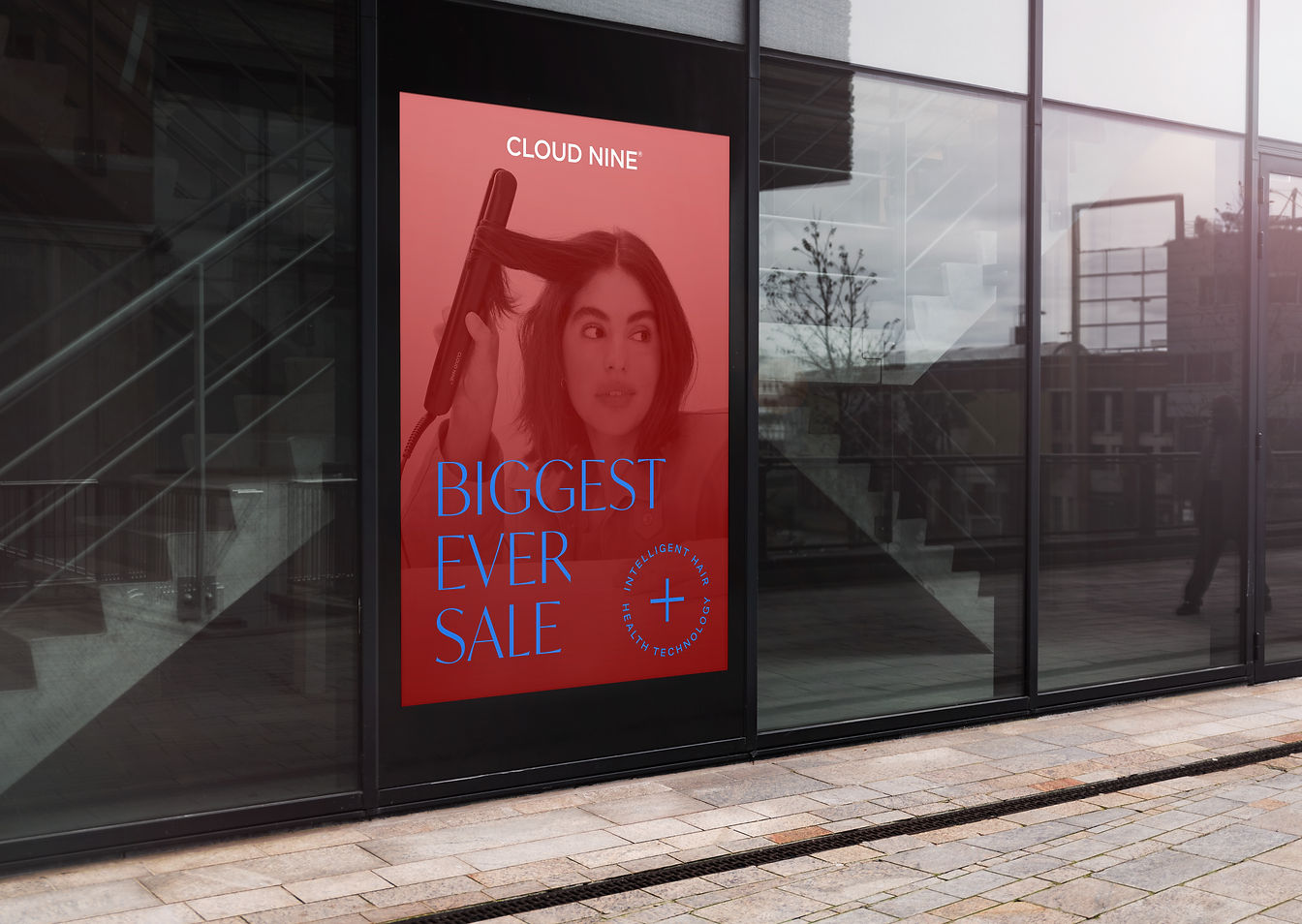 Print advertisement on glass wall with red model image, Cloud Nine logo, blue sale roundel.