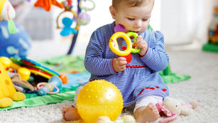 Nina mordiendo juguetes