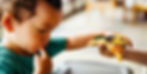 Bebé comiendo pizza, un alimento procesado alto en contenido de sal