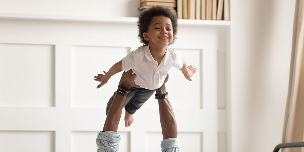 Papá jugando con su hijo pequeño a volar, una forma de juegos físicos
