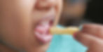 Niño pequeño comiendo papas fritas, mostrando hábitos poco saludables