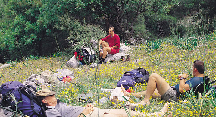 Hikers resting in a flowery field at Kalkan Gallery.