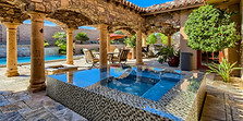 Back Yard Real Estate Photo with Jacuzzi and Bungalow style patio cover. Able to see beautiful water glisten and a bright blue sky