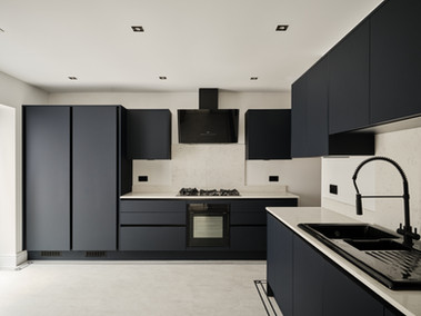 A photo of a grey kitchen with white floor and countertops