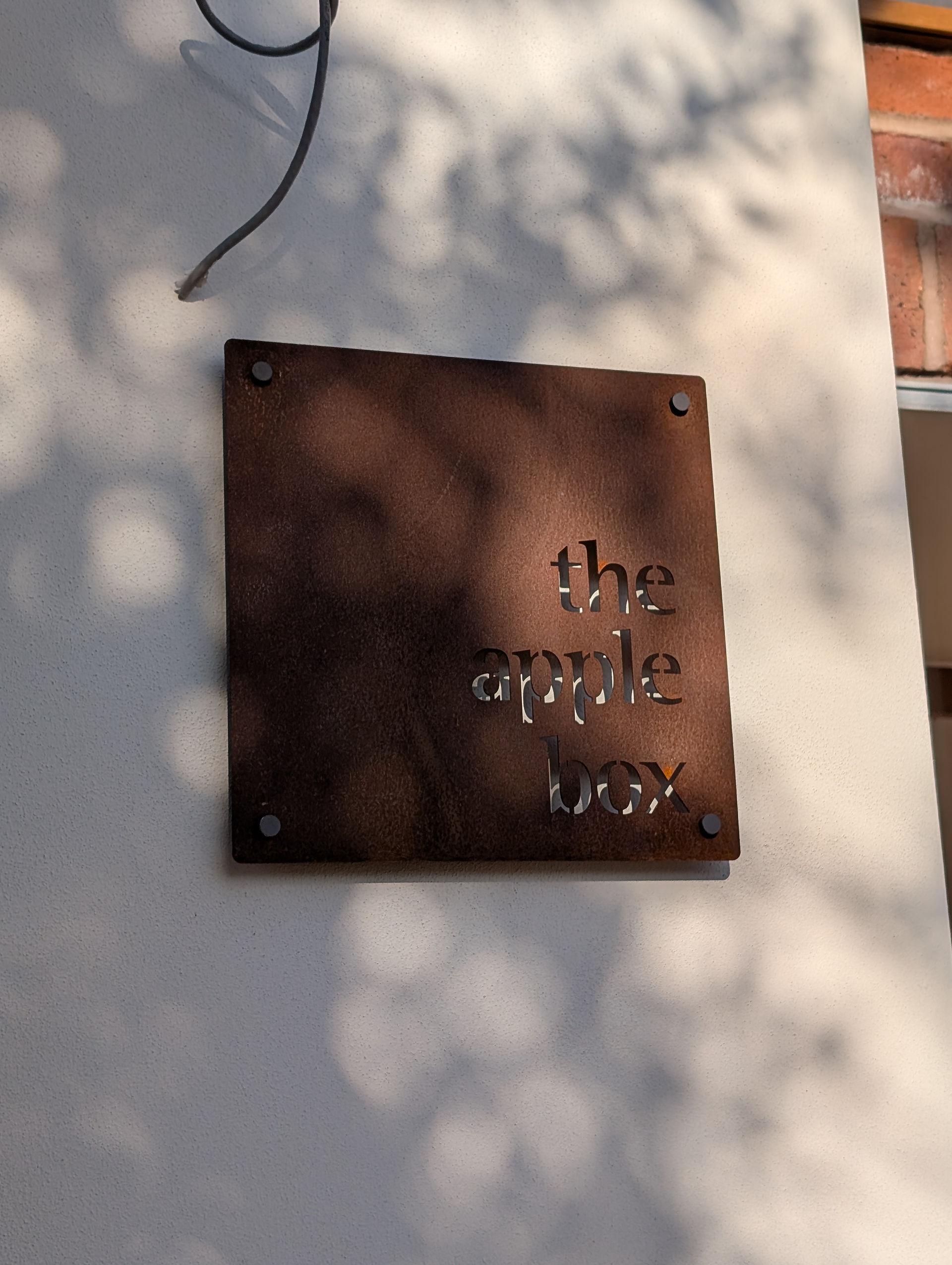 Steel house sign on white render wall