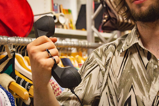 Een man in een tweedehandswinkel met een retro telefoon