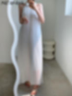 Femme portant une robe plissée longue sans manches blanche, en pleine lumière estivale