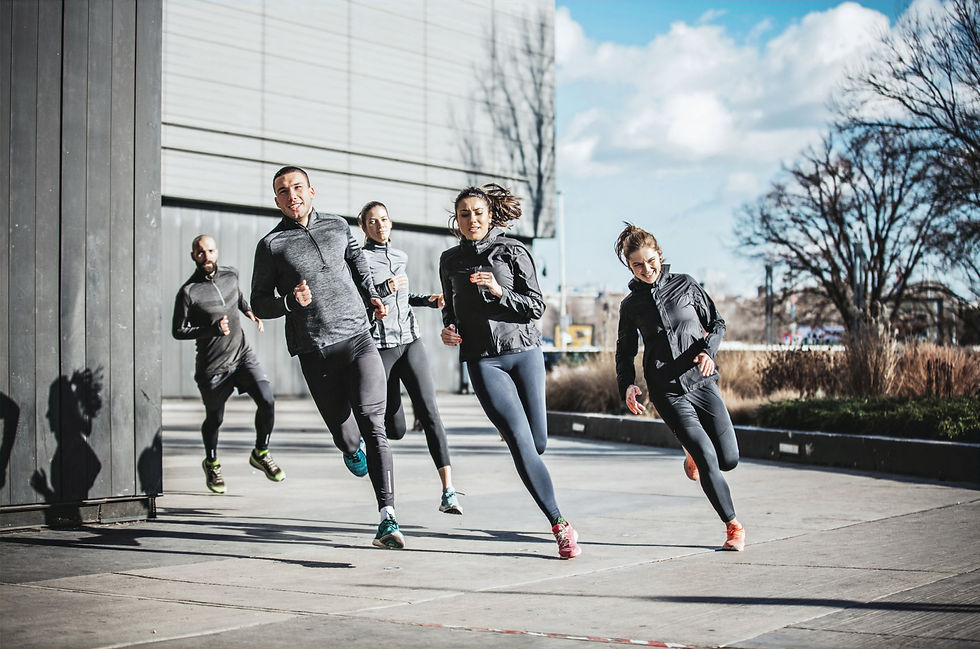 Portrait d'un groupe de coureurs, portant des pantalons joggings, en pleine action, vue de face.