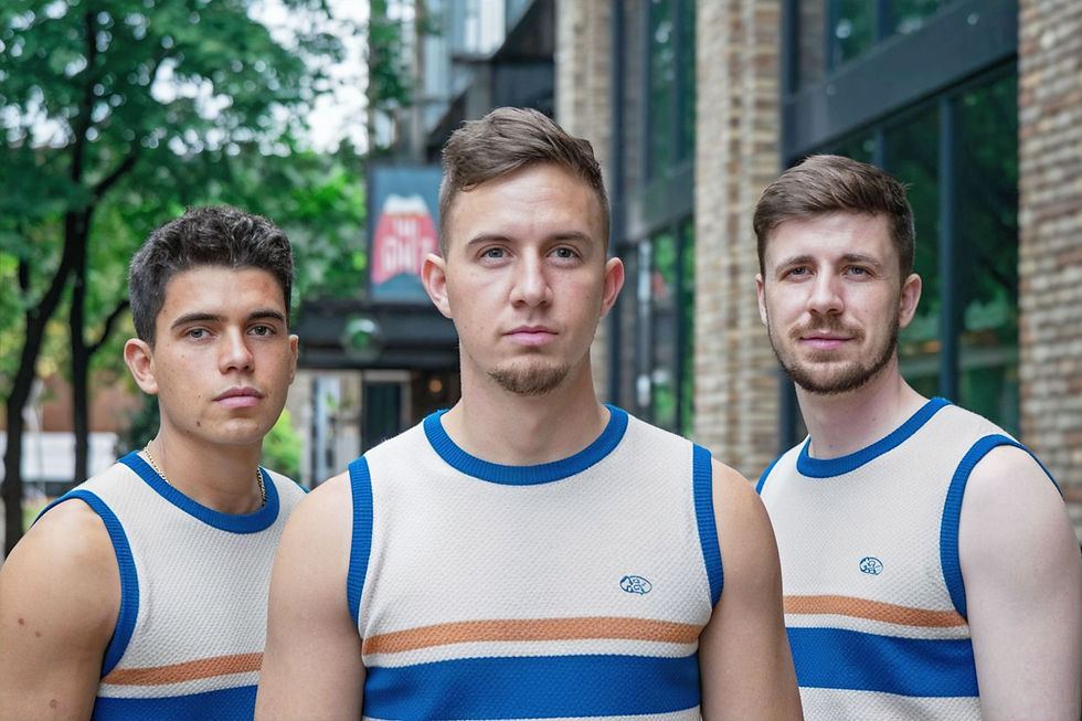 Portrait of three men wearing sleeveless t-shirts, white/blue/orange, front view.